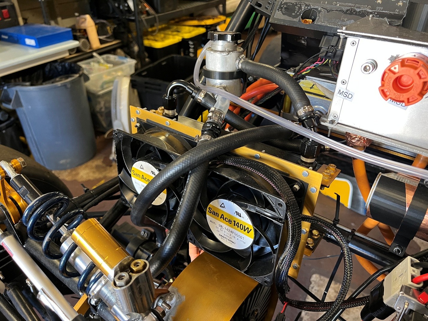 Close-up of a workshop cooling loop with two San Ace 140W fans, clear tubing, and braided cables in a metallic frame.